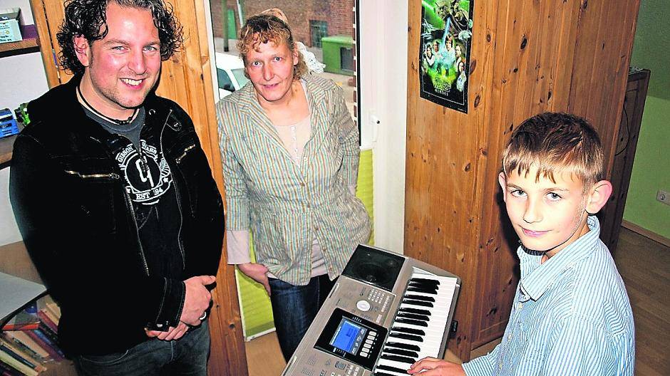  Niko freut sich über den Besuch von René Pütz im Haus Kranenbach. Gemeinsam mit seiner Kinderdorfmutter Nicole Kommer zeigt er dem Musiker sein Keyboard. 