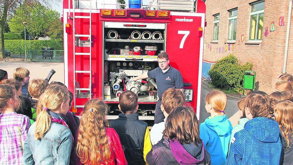 Feuerwehrmann Bernhard Horster aus Nierst klärt Meerbuscher Grundschüler über die Feuerwehr auf.
