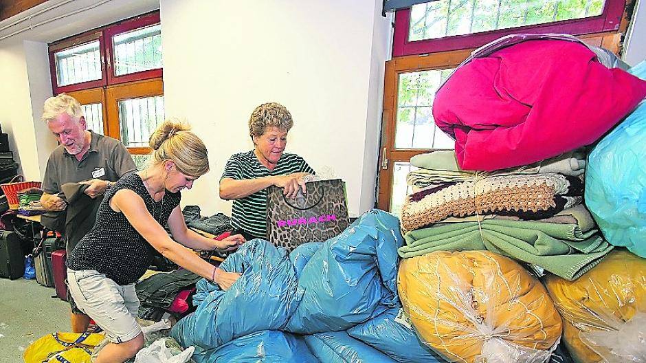  Vor der Halle sind Zelte aufgebaut worden, in denen die Neuankömmlinge ärztlich untersucht, registriert und verpflegt werden. In der Sporthalle bauten Helferinnen und Helfer von Johannitern und Feuerwehr Feldbetten auf, die durch Sichtschutzwände getrennt sind. 