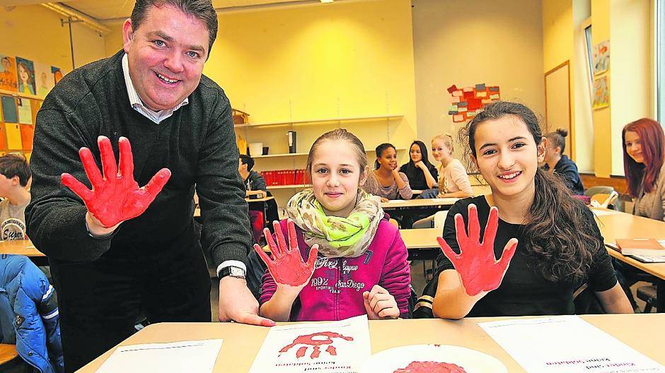  Gemeinsam ein Zeichen gegen Kindersoldaten setzen: Ansgar Heveling, Kyra und Verona haben ihre Hände bemalt. 