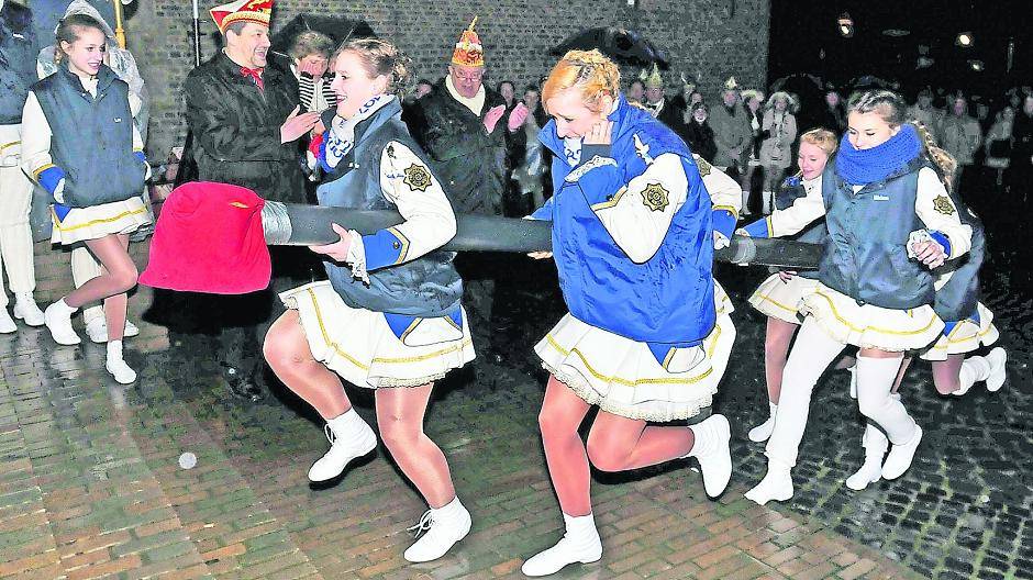 Wilder Ansturm — mit Rammbock — auf das Schlosstor! Und weil es gleich laut knallt, hält sich eine der Tänzerinnen der Prinzengarde der Stadt Willich vorsichtshalber schon mal ein Ohr zu. Drei Anläufe sind in der Regel notwendig, um das schwere Eichenportal aufzubrechen.