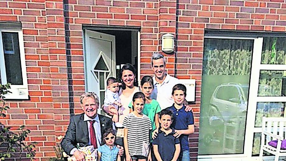 Bürgermeister Josef Heyes (knieend) mit Irene und Raul Jovino vor der Tür ihres Hauses an der Kehner Straße.