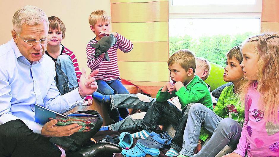 Eine Szene wie bei einem Familienfest, wo der Großvater seiner Enkelschar vorliest. Hartmut Fischer, Top-Manager von Saint-Gobain, hat am Donnerstag im Kindergarten „Glückskinder Willich“ aus einem Jubiläumsbuch seines Konzerns vorgelesen.