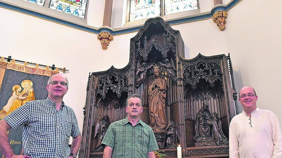  Ulrich Bons und Peter Theisen vom Kirchbauverein mit Pfarrer Jürgen Lenzen vor dem Marienaltar, der nun restauriert werden soll. 
