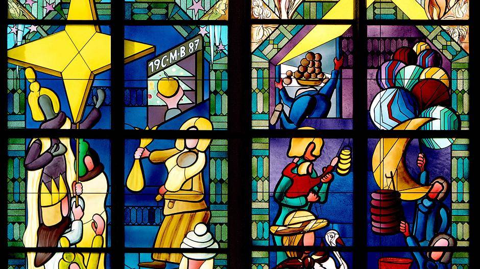 Sternsinger, Martinslaternen, die Heiligen drei Könige und Weckmann auf dem Brauchtumsfenster der St. Vitus-Kirche Oedt.