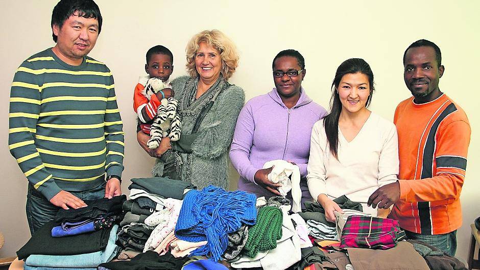  Bewohner der Asylbewerber-Unterkunft an der Kochstraße in Willich sortieren Kleiderspenden der Willicher Bevölkerung für die Neuankömmlinge im Katharinen-Hospital, das in ein Übergangswohnheim für Flüchtlinge umgewandelt worden ist. Mittendrin Jutta van Amern, Vorsitzende des Arbeitskreises Fremde. 