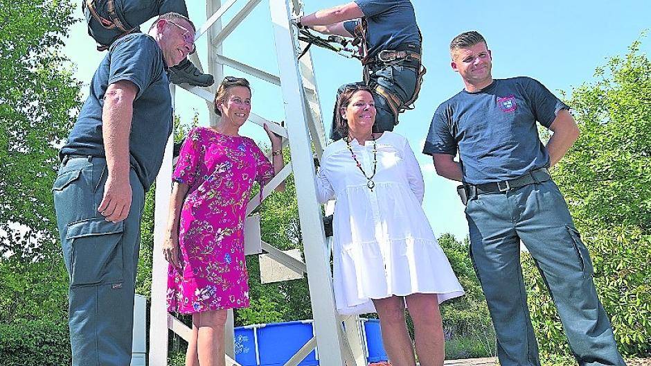  Das Foto zeigt einen Teil der Anlage, an dem Höhenrettung geübt werden kann. Neben den Feuerwehrmännern sind zu sehen Bürgermeisterin Sabine Anemüller (links) und Birgit Lücker vom Bauunternehmen Lücker, das die Errichtung der Ausbildungsanlage maßgeblich unterstützte. 