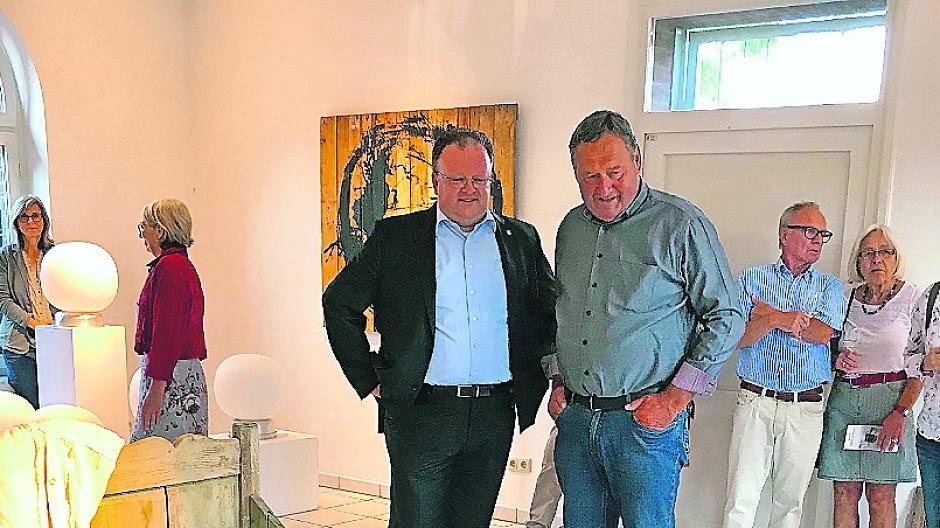 Politik trifft Kunst: Bürgermeister Marc Venten und Hans-Willi Türks, stellvertretender Bürgermeister aus Pesch, diskutieren über dieses ausgefallene Ausstellungsobjekt, das den Namen „Das Bett“trägt.