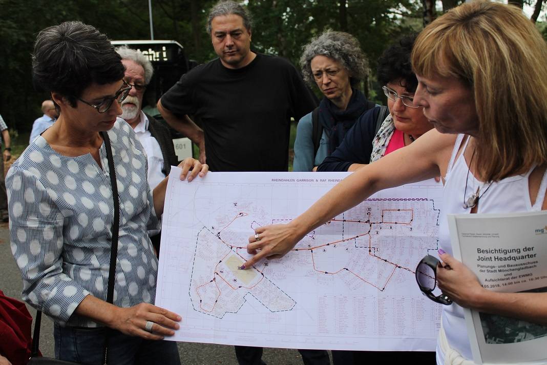 Konversationsbauftragte Annette Pfenning (r.) erklärt Bauausschussmitgliedern das Gelände.