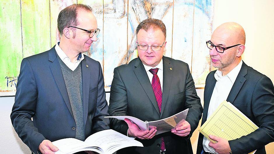Kämmerer Thomas Dückers, Bürgermeister Marc Venten und Technischer Beigeordneter Georg Onkelbach (von links) studieren die „Zahlen des Jahres“ für Korschenbroich.