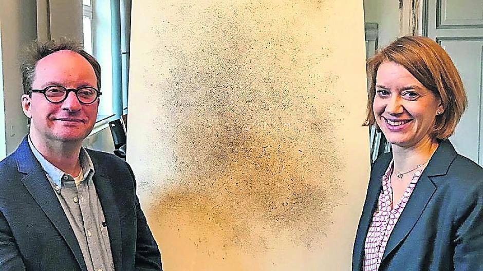 Marcell Feldberg und Friedericke Braun mit einem bild aus der Serie Urwolke des Schweizer Künstlers Harald Naegeli.