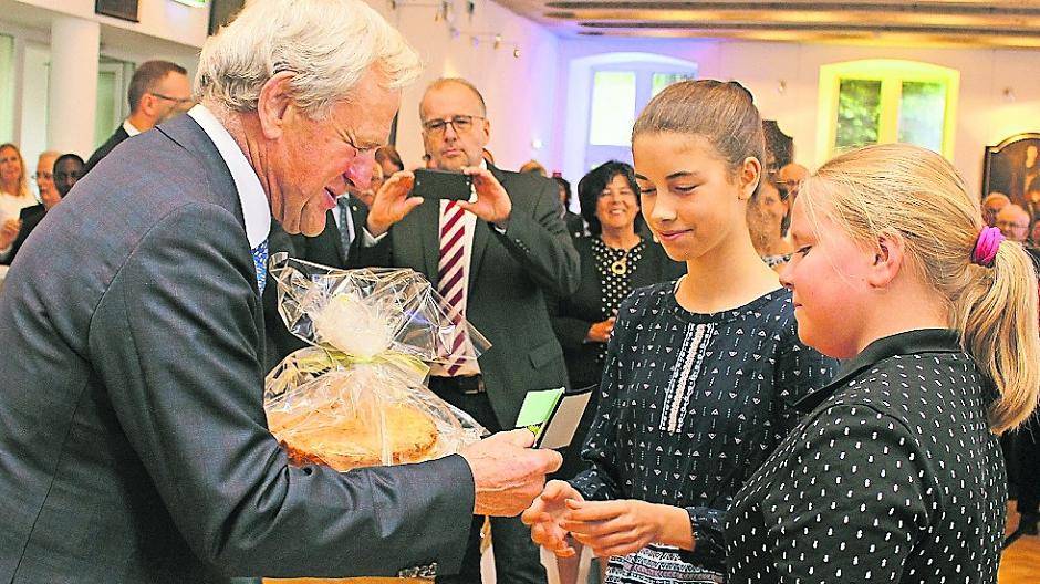  Zwei der offiziellen Patenkinder von Bürgermeister Josef Heyes überraschten ihn mit einem selbst gebackenen Bienenstich, seinem Lieblingskuchen. Foto: Schütz 