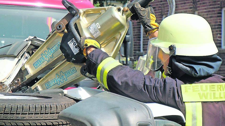 Ein Pkw hat sich überschlagen. Um den Verletzten retten zu können, wird eine Tür mit dem hydraulischen Spreizer geöffnet.