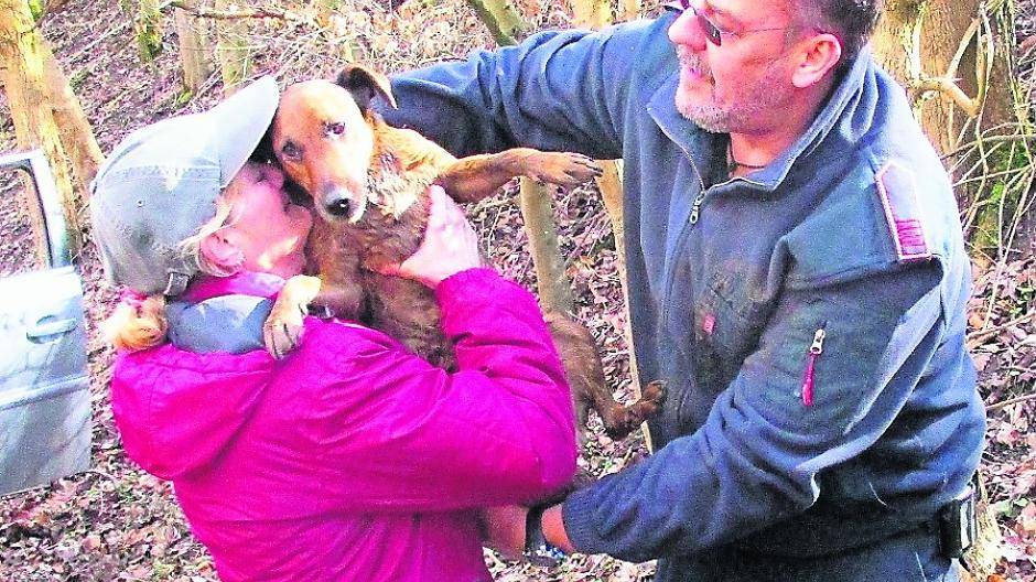  Überglücklich nimmt die Hundebesitzerin ihren Vierbeiner aus den Armen eines Feuerwehrmanns entgegen. 