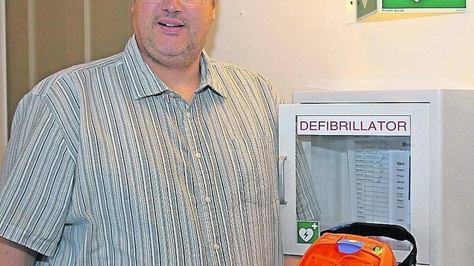 Christian Karpenkiel zeigt einen der beiden Defibrillatoren, die im Schloss Neersen hängen (Erdgeschoss und 2. Etage).