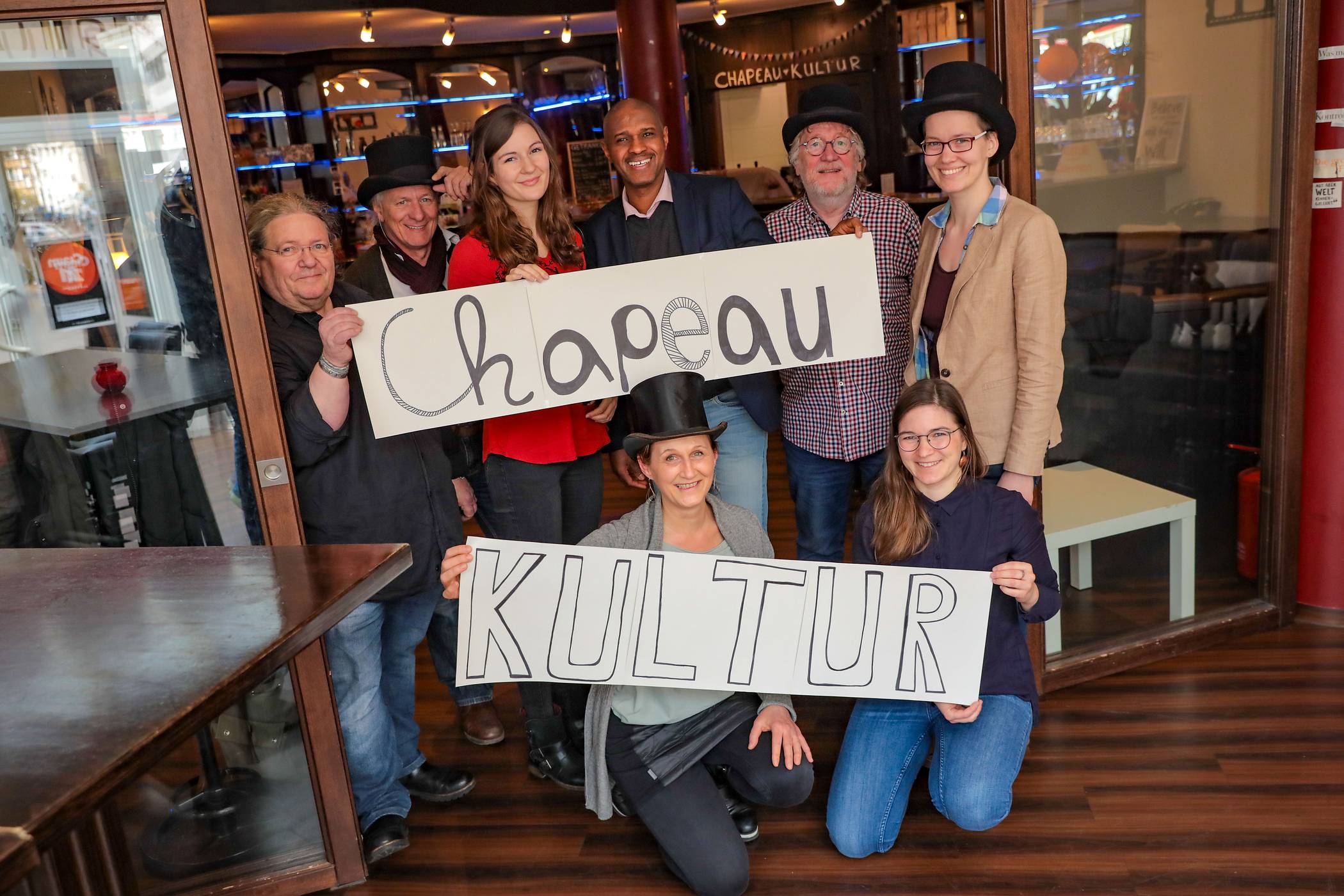  Hängen sich voll rein fürs Chapeau Kultur (hinten v.l.): Mika Ernst (Bassist von Claim 21), Norbert Schoeler (Geschäftsführer SKM Rheydt und Gitaarist bei Claim 21), Sonja Tucinskij (Kulturkram), Alpha Balde (Vorstandsvorsitzenderr VKI), Wolfgang Riehn (Geschäftsführer VKI) und Rebeca Schmidthüsen (Kulturkram) sowie (vorne v.l.) Anna Papoulias (SKM Rheydt) und Katharina Hieber (Quartiersmanagement). 