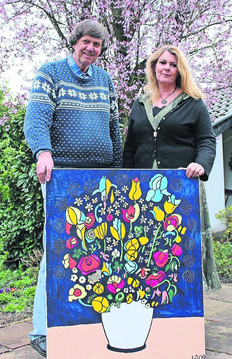 Dr. Wolfgang Boochs und Beate Krempe mit einem Bild, das Boochs selbst gemalt hat.