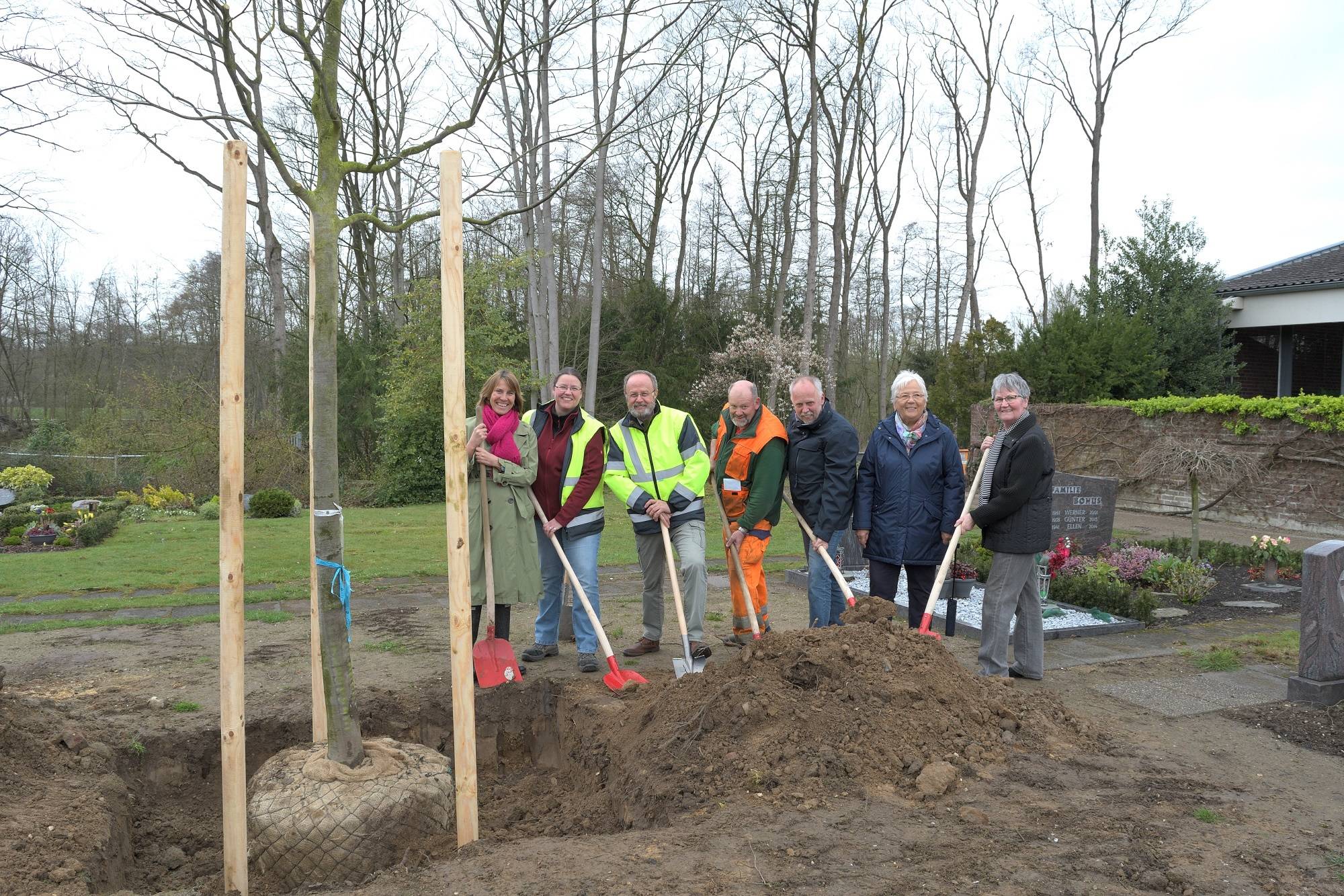  Bürgermeisterin Sabine Anemüller mit Vertretern der Städtischen Betriebe und des Bürgervereins Boisheim beim Pflanzen der neuen Bäume auf dem Boisheimer Friedhof. 