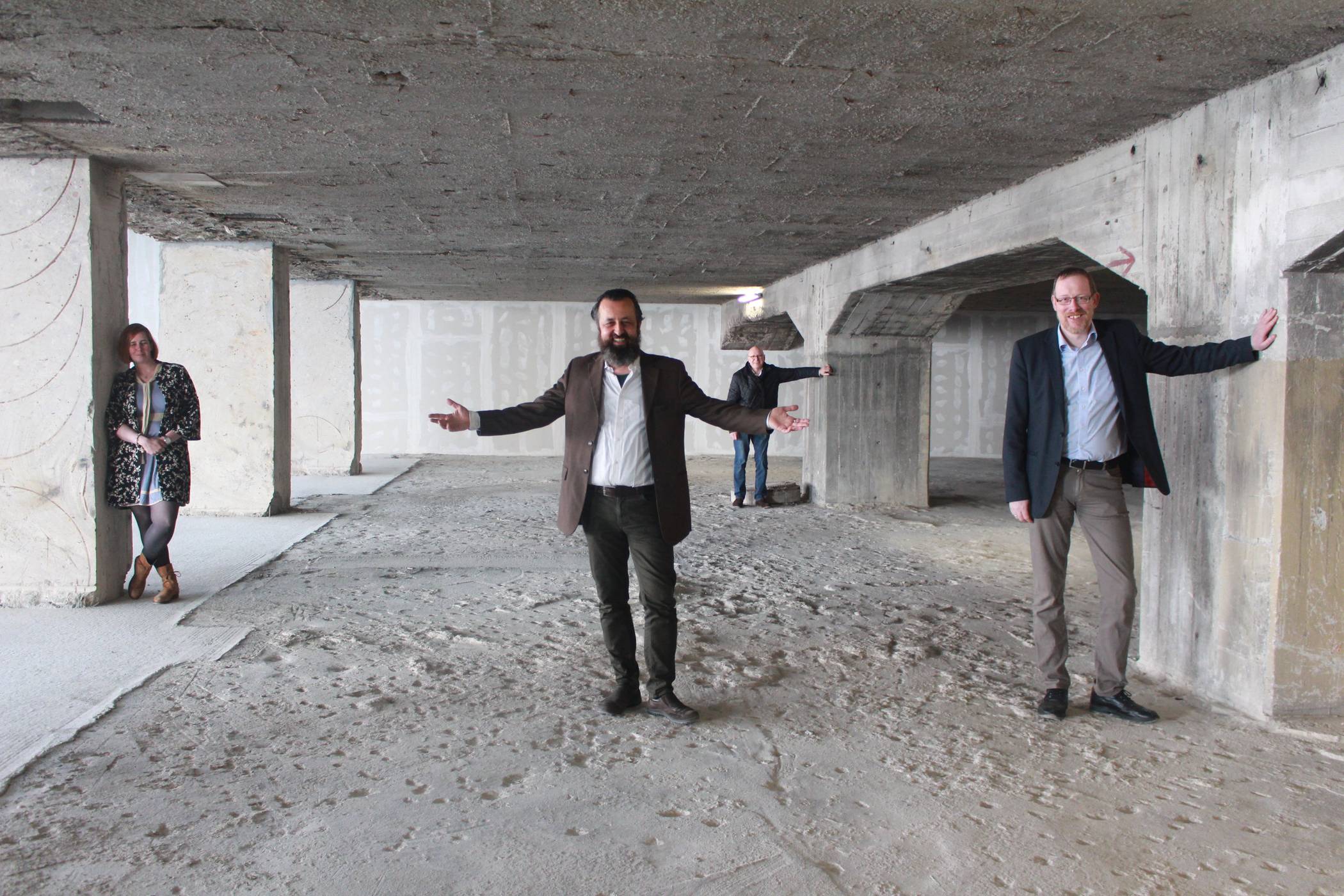  Regisseur Franz Mestre (Mitte) hat den leerstehenden Luftschutzbunker als attraktive Spielstätte entdeckt. Sandra Franz, Leiterin der NS-Dokumentationsstelle, und Dr. Christoph Moß (r.), stellvertretender Leiter des Stadtarchivs, bauen dazu eine Ausstellung mit historischen Dokumenten auf. Bühnenbildner Frank Andermahr (hinten) nutzt die Kulisse für innovative Videoprojektionen. 