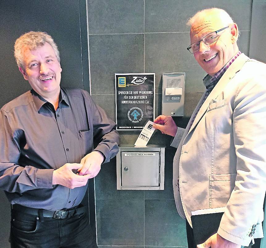 Bernd Bodenbenner vom Deutschen Kinderschutzbund Viersen mit einem Mitarbeiter vom neuen Edeka-Markt Zielke in Viersen an der Flaschenpfand-Box.