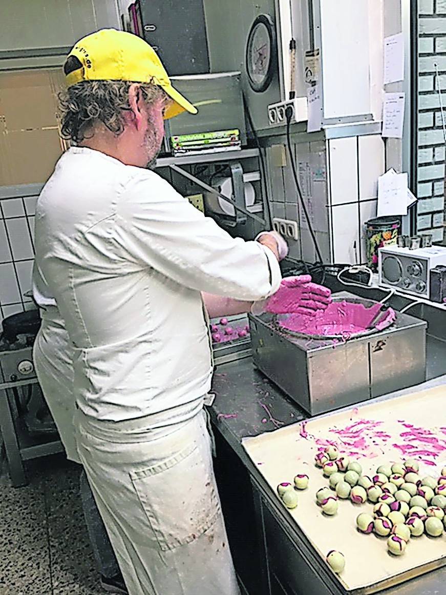  Thomas Greis bei der Produktion von Pralinen. Die Hülle aus weißer Schokolade wird mit der Ruby-Schokolade gefüllt. 