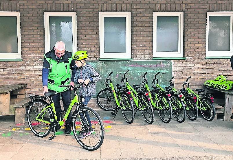  Dieter Bach, Kreisverkehrswacht NRW, hilft den Schülern dabei, die neuen Fahrräder richtig einzustellen.Verkehrsminister Hendrik Wüst (3.v.l.) übergab gemeinsam mit Klaus Voussem (4.v.l.), Vizepräsident der Landesverkehrswacht NRW, im Beisein von Landrat Dr. Andreas Coenen (5.v.l.), Nettetals Bürgermeister Christian Wagner (3.v.r.) und LVW-Direktor Burkhard Nipper (r.) zwölf Räder und 30 Helme an Schulleiterin Susanne Dückers (2.v.r.) und Dieter Bach (l.) von der Kreisverkehrswacht Viersen. 