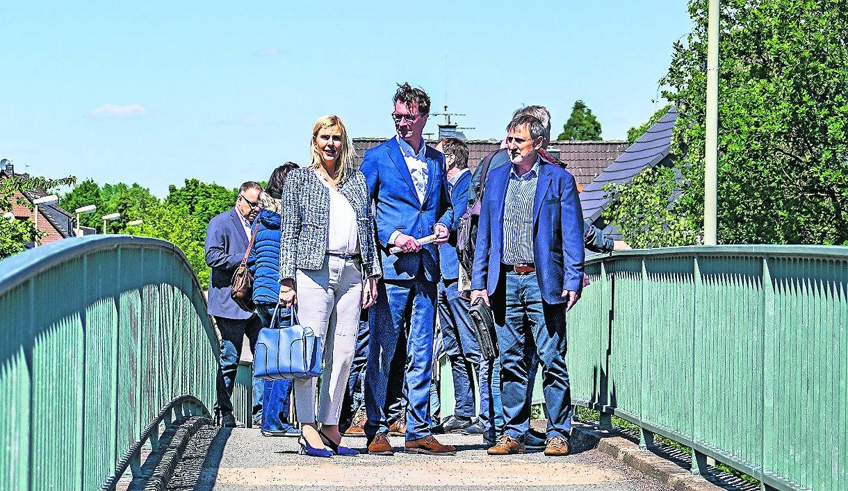 CDU-Landtagsabgeordneten Petra Vogt, Landesverkehrsminister Hendrik Wüst und CDU-Mitglied Wolfgang Schwertner auf der Mündelheimer Fußgängerbrücke.