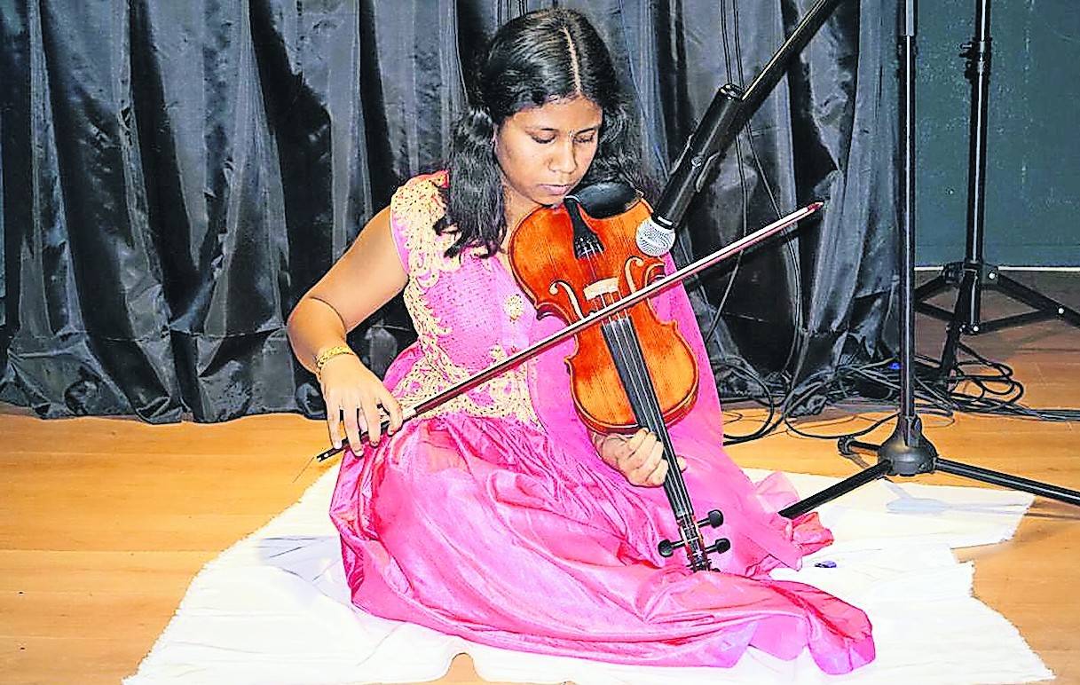 Die Geigerin Warshiya Pirabaharan zeigt am 9. Juli, wie tamilische Geige gespielt wird. Dabei wird die Geige mit den Füßen gehalten.