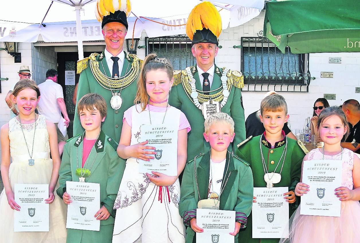  Das Kinderschützenkönigshaus (von links): Ministerin Christina Titze, Minister Ben Hesse, Königin Liliane Knappe und König Hugo Nauels, Minister Laurenz Friedrich und Ministerin Albina Azizi. Im Hintergrund Minister Frank Mertens und König Norbert Silkens. 