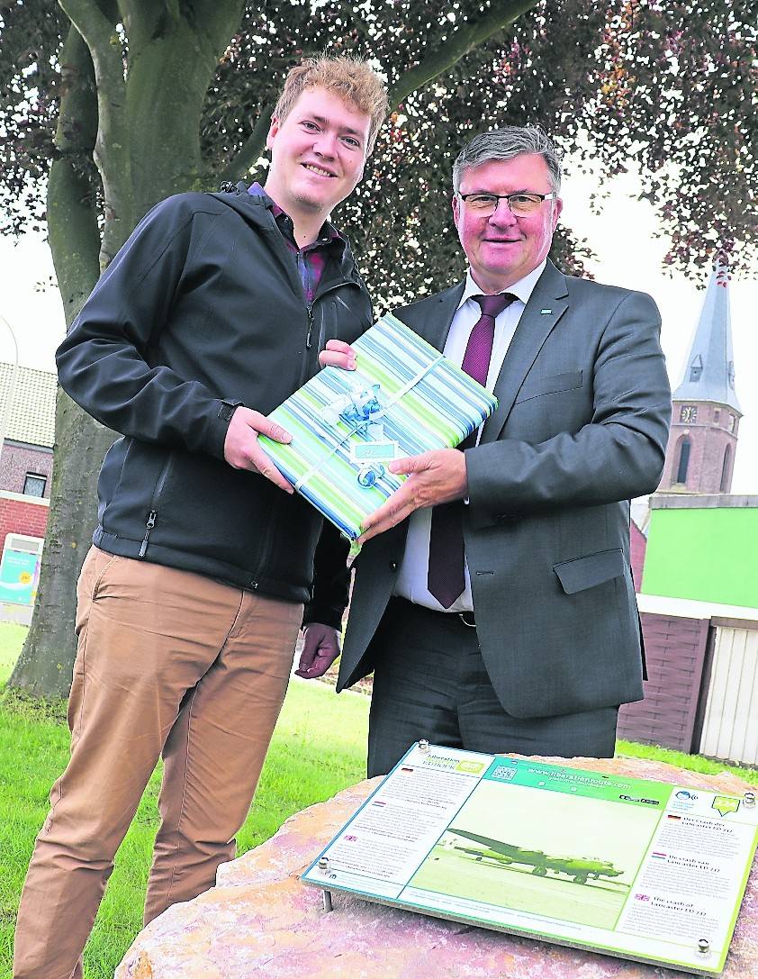 Bürgermeister Kalle Wassong (r.) bedankte sich mit einem Geschenk bei Dwayne Beckers, der die Hörstelle auf der Liberation Route durch seine ehrenamtliche Arbeit möglich machte.