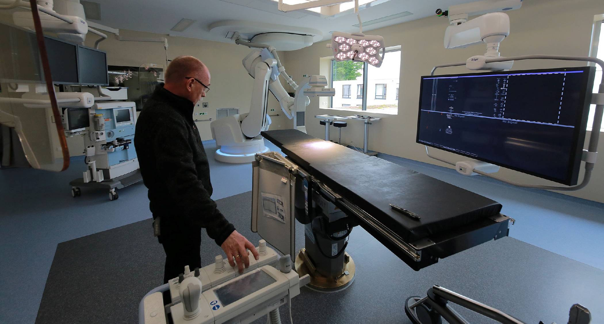 Ulrich Jansen, Leiter Medizintechnik, führt die Robotereinheit im neuen Hybrid-OP vor.