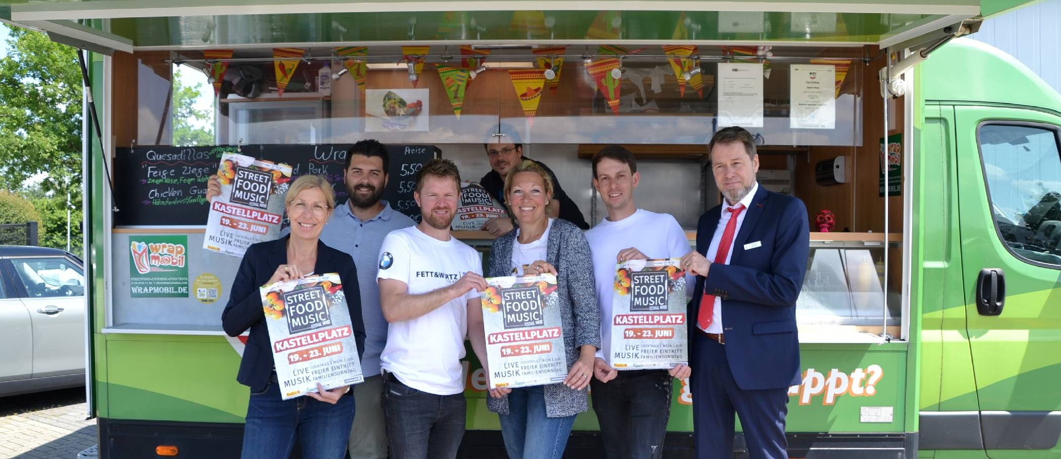 Freuen sich auf das Street Food Music Festival (v.l.): Marion Fett-Walter (Geschäftsführung Fett und Wirtz), Robert Abdiu und Jens Gintze (Verkaufsteam Mini, Fett und Wirtz), Sabine Blum (Fett und Wirtz (Marketing), Alexander Binevitch (Just Festivals) sowie Thomas Münker (Sparkasse am Niederrhein) vor dem Wrap Mobil von Sascha Maes (im Hintergrund).