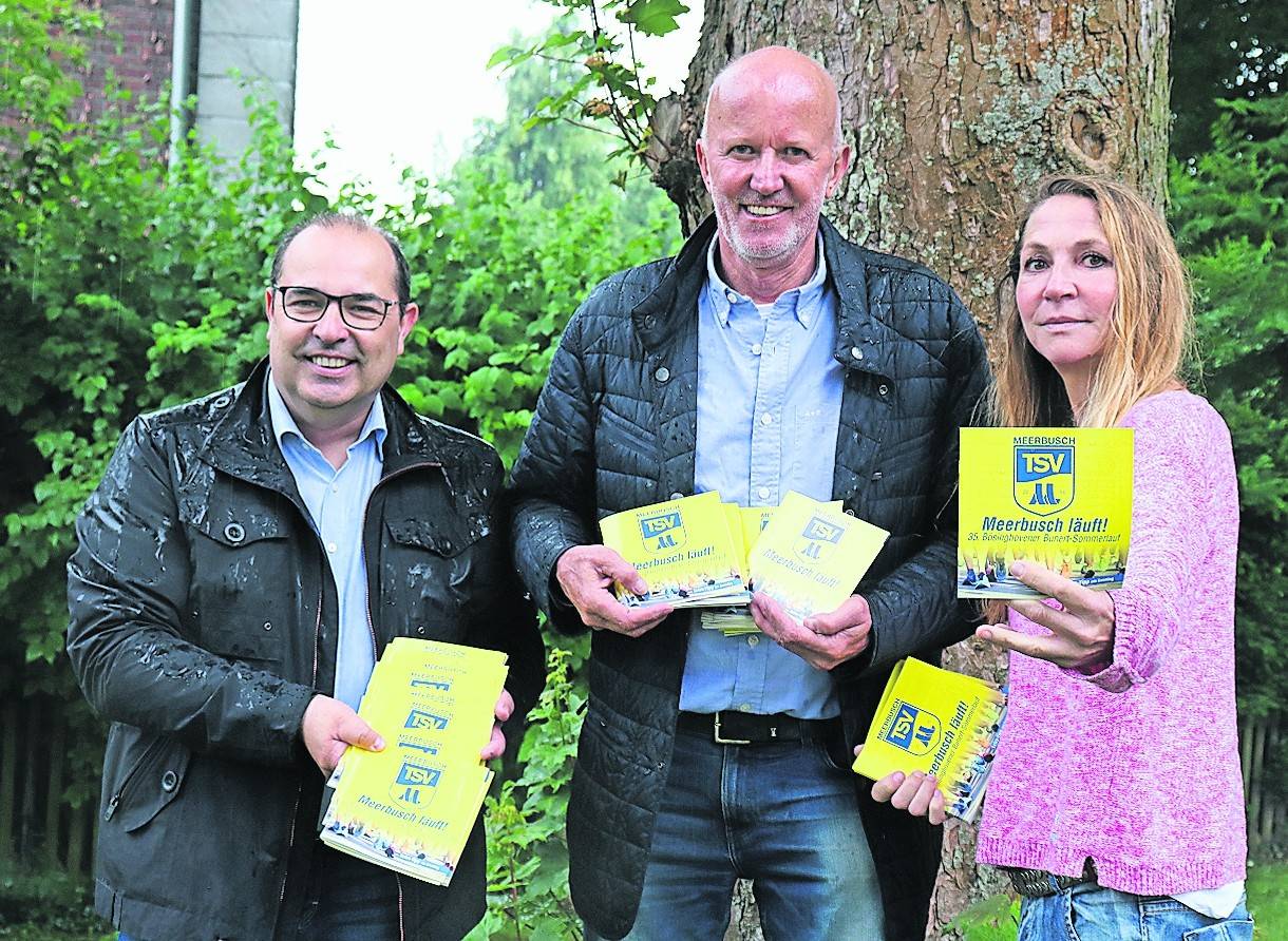  Bernd Arnolds (Extra-Tipp), Dieter Schmitz (TSV) und Indra Schlebusch (Extra-Tipp, von links) freuen sich über die neuen Hefte. Da konnte auch der starke Regen die Stimmung bei der Übergabe der Hefte nicht trüben. 