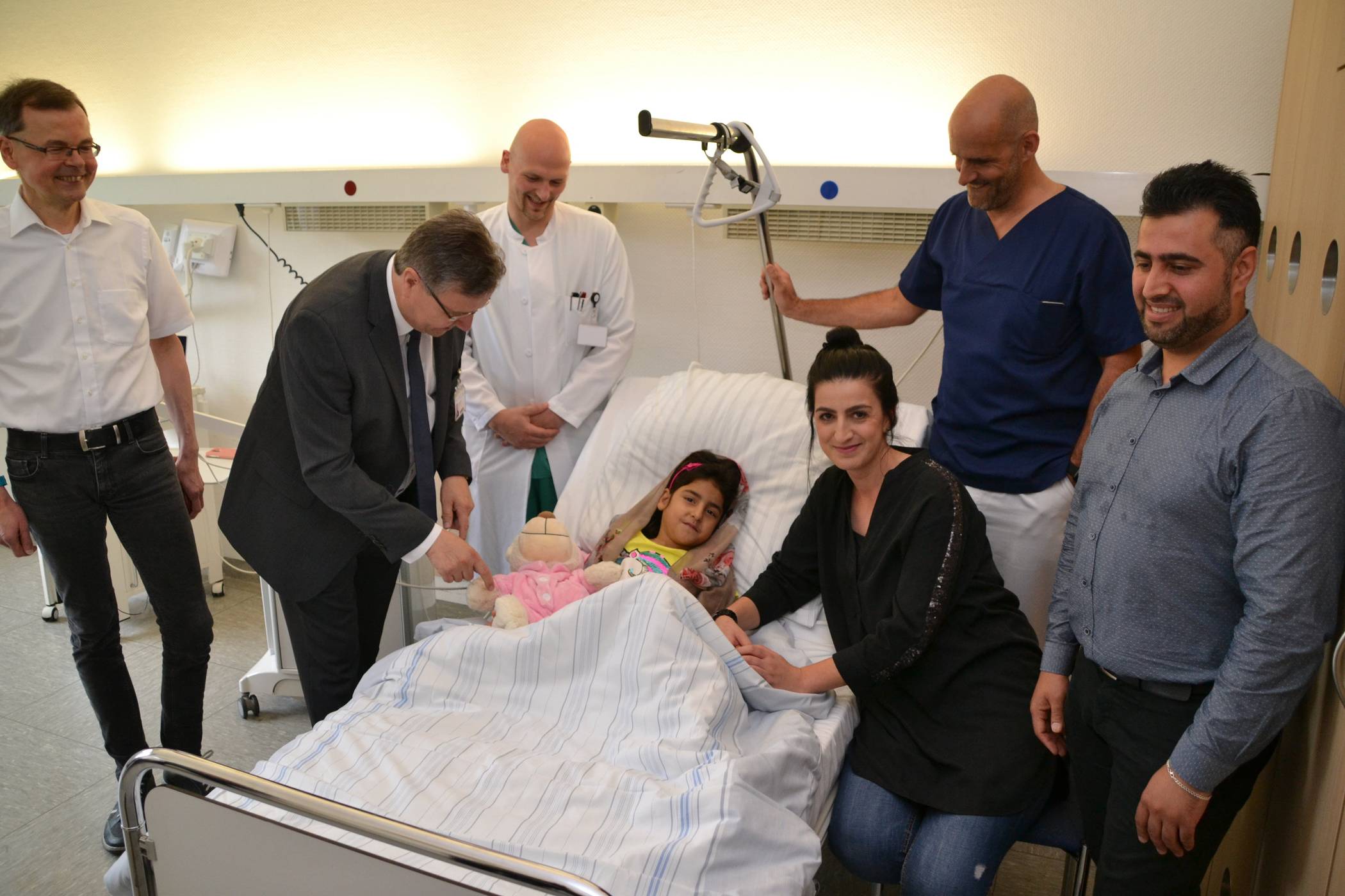  Umrahmt von Markus Dewender (l.) und Siddiqullah Hotak (r.) von KBU, St.-Josef-Geschäftsführer Ralf Nennhaus, den Ärzten Benjamin Weidle und Michael Jonas und Gastmutter Kader Deniz: die wieder glückliche Bibi Hawa. 