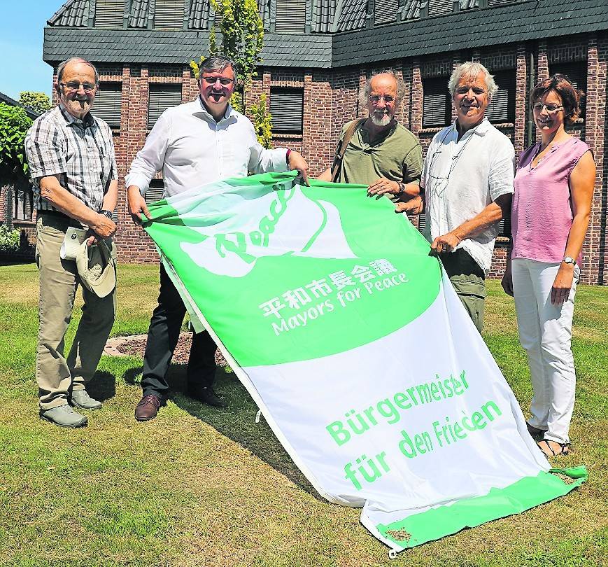 Zeigen Flagge (von links): Dr. Helmut Küster (IPPNW), Bürgermeister Kalle Wassong, Herbert Hochheimer (IPPNW), Rolf Huneus (IPPNW) und Koordinatorin Ursula Gilleßen von der Gemeinde.