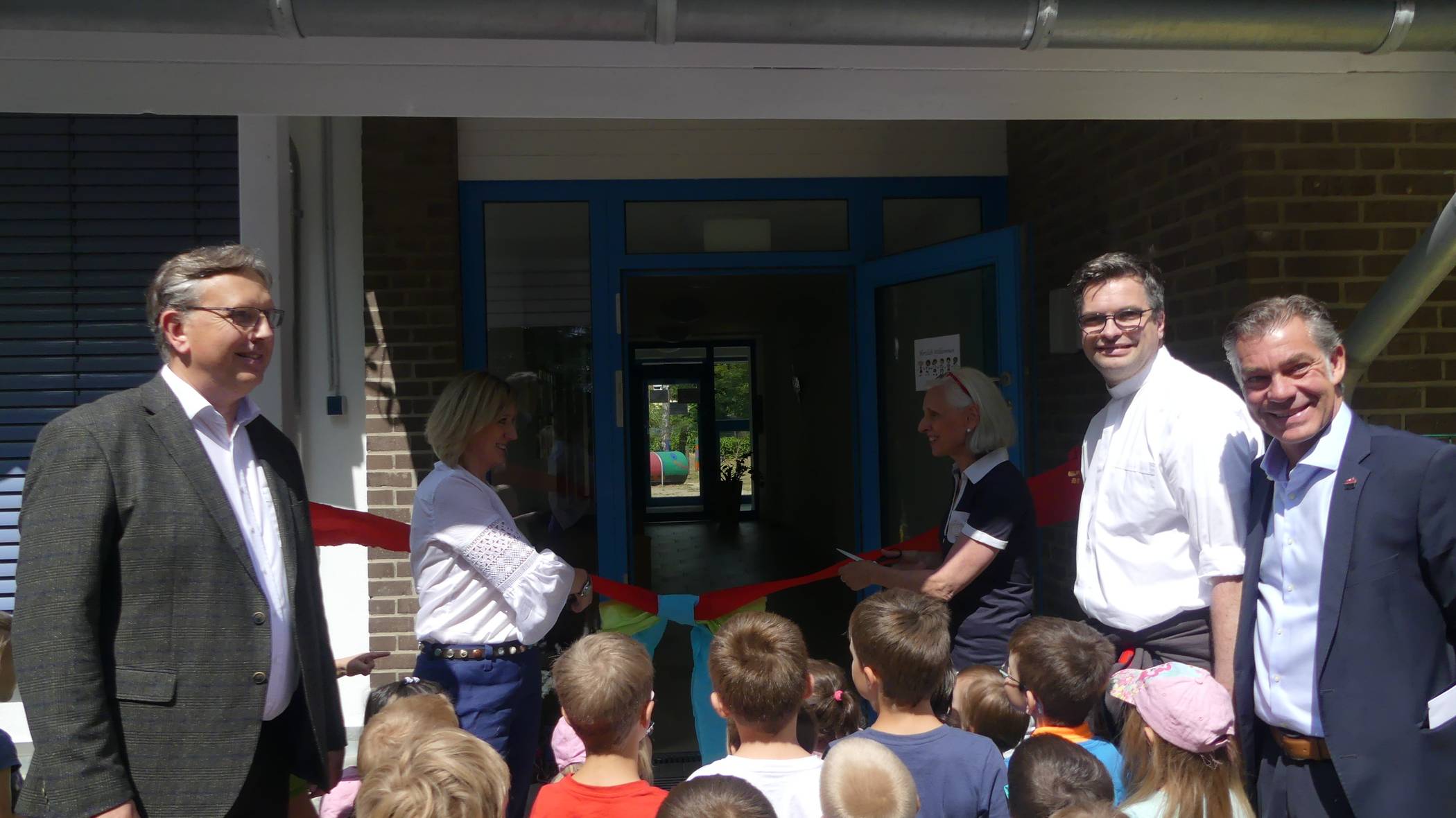  Zerschneiden des Bandes am Eingang des neuen Anbaus: Winfried Goertz, Sylwia Digiacomo, Renate Stiels, Frank Schürkens, Bürgermeister Frank Gellen (v.l.). 
