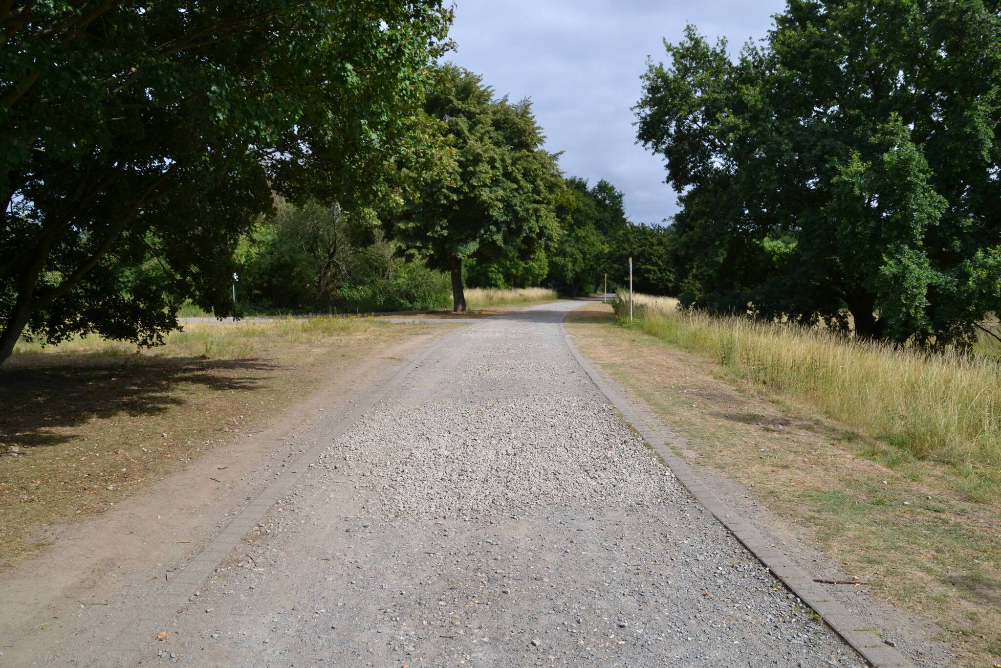 Auswaschungen auf den Wegen wurden mit ganz grobem Schotter verfüllt. Mit Fahrrad, Rollator oder Kinderwagen kommt man an diesen Stellen in Schwierigkeiten und muss auf die Wiese ausweichen.