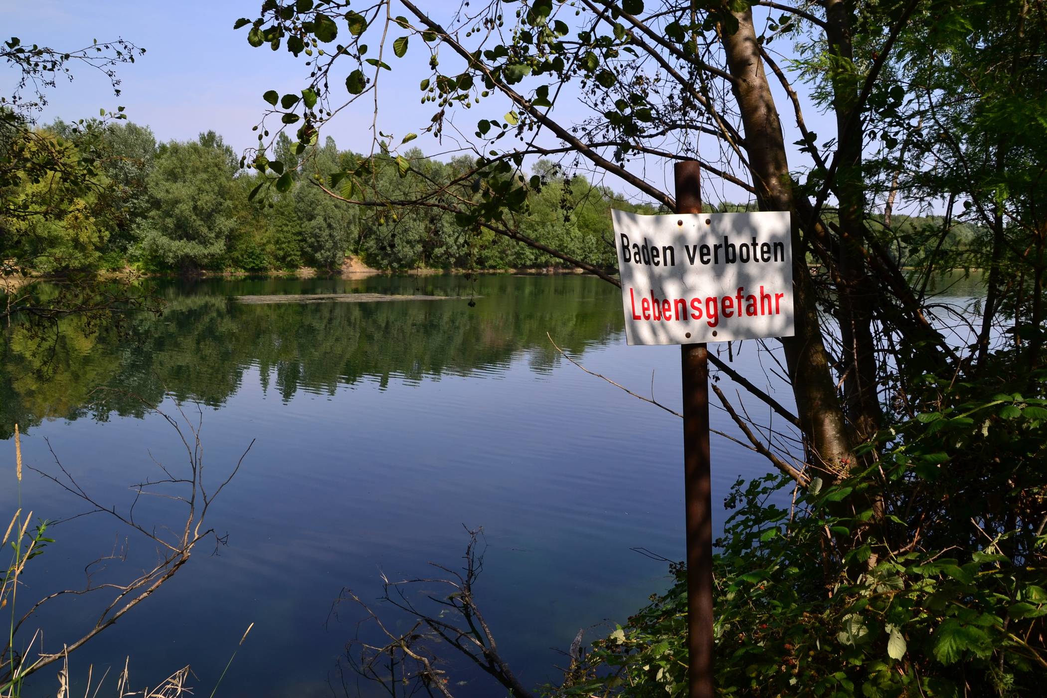  Am Uettelsheimer See ist das Baden offiziell verboten, dennoch tummeln sich einige Besucher bei der derzeitigen Sommerhitze im Wasser. Aufgrund von Blaualgen könnte das allerdings noch gefährlicher sein als ohnehin schon.  