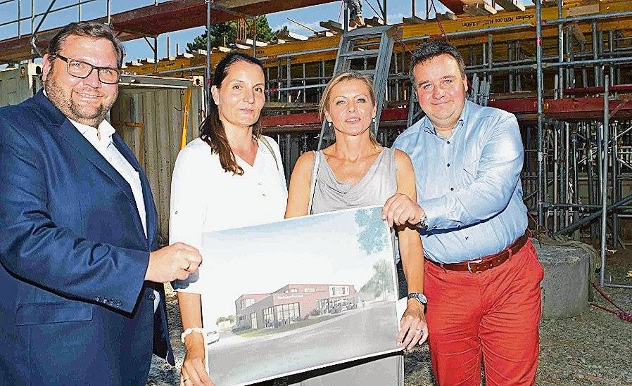  Zeigen vor der Kulisse des Rohbaus, dass der fertige Erweiterungsbau in seinen funktionalen Formen ein wenig nach „Bauhaus-Architektur“ wirken wird: (v.l.) Oberbürgermeister Frank Meyer, Jutta Heintz vom städtischen Gebäudemanagement, Architektin Katharina Kulla und Schuldezernent Markus Schön. 