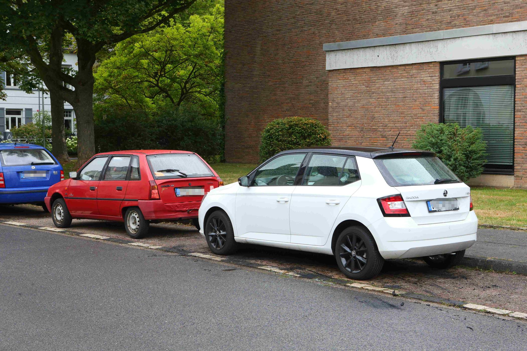 Dort wo jetzt der weiße PKW steht sind noch Brandspuren zu erkennen. Dort fing das Auto des Politikers in der Nacht Feuer.