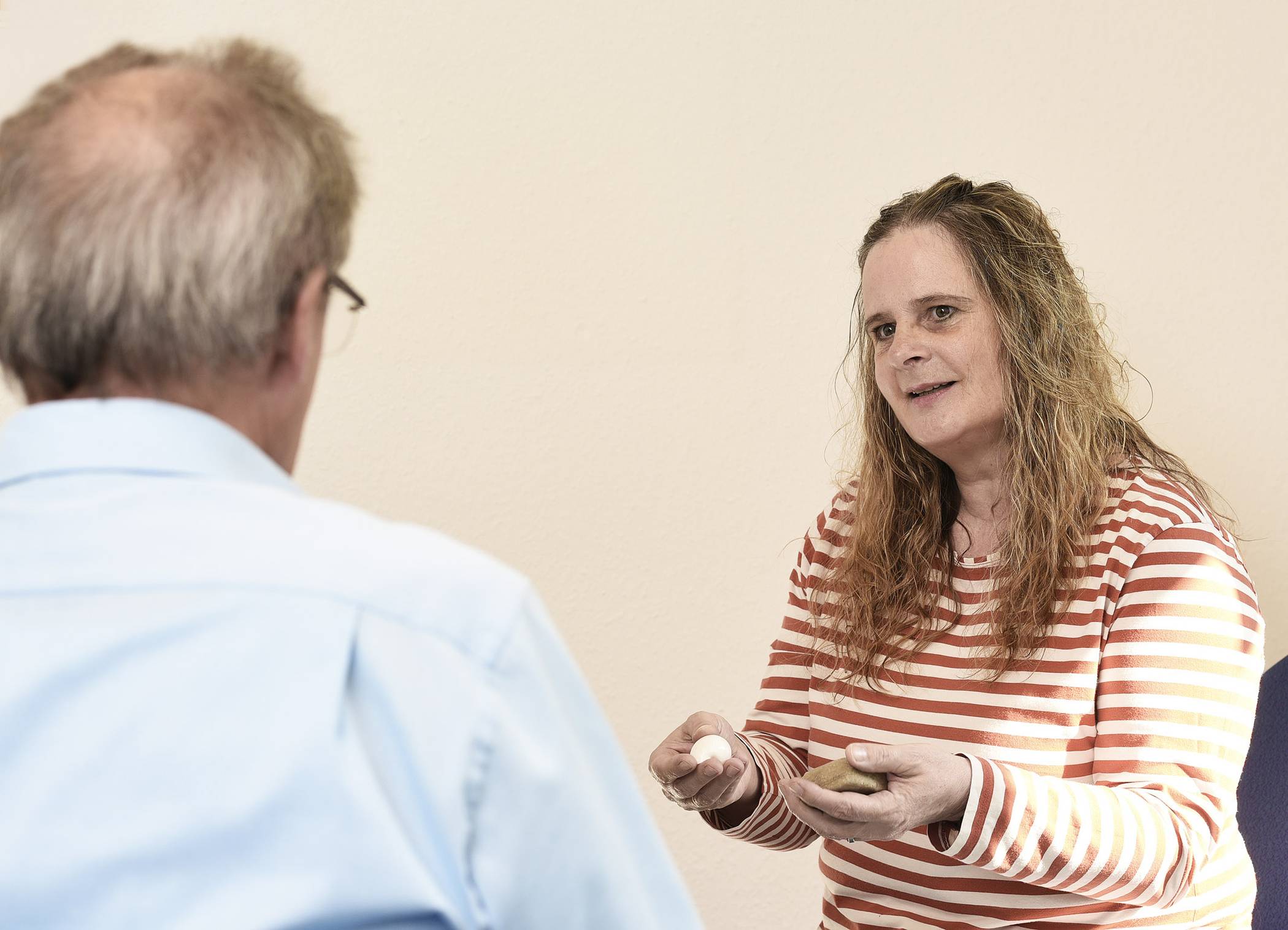   Andrea Groß-Reuter, Leiterin für Beratung und Rehabilitation der Caritas-Fachambulanz, berät einen Klienten. Symbole wie eine Pyramide, Steine oder Muscheln können bei der Behandlung helfen. 