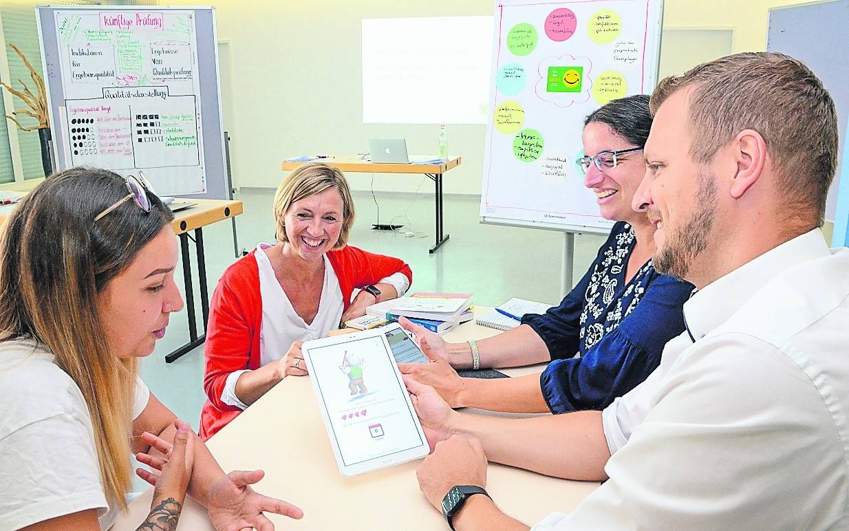 So macht Lernen Spaß: „Supernurse“-Erfinderin Judith Ebel (2.v.l.) erläutert den Caritas-Pflegefachkräften Yalda Ghoochi (l.), Katrin Standfuß und Georg Hövelmans die Quiz-App.