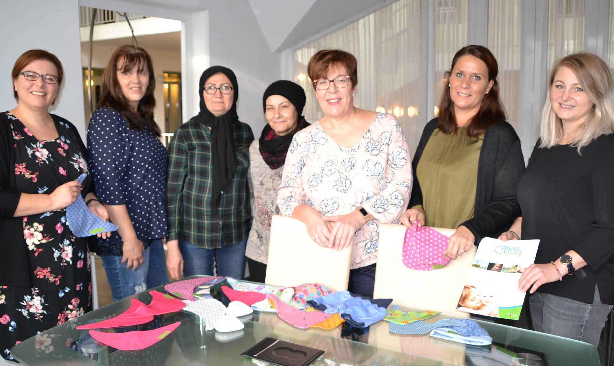 Sarah Bernstein, Birgit Kraemer, Mahrach Aslampur, Seham Mohammed, Rosemarie Kaltenbach, Michaela Bothen und Maike Holthuis (v. l.) stellen das Beratungsangebot „Frühe Hilfen“ in Rheinberg vor, im Rahmen dessen die Willkommenspakete für Neugeborene verteilt werden - mit vielen Informationen, aber auch niedlichen Geschenken.