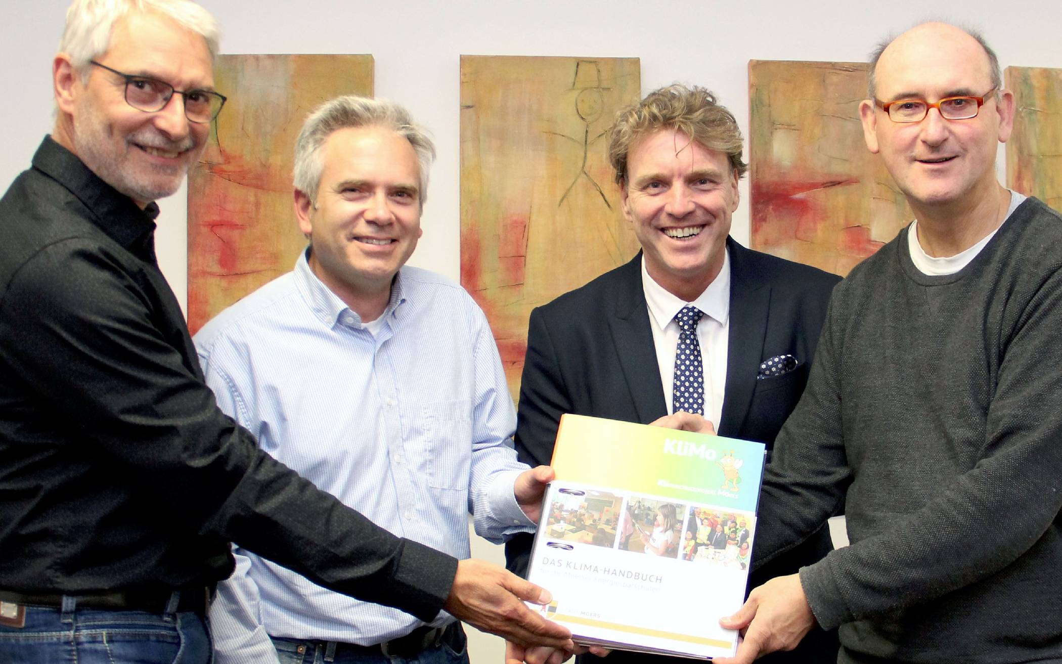  Gerhard Tomberg (zgm), Marc Alexander Horsters (Leiter des zgm), Bürgermeister Christoph Fleischhauer und Klaus Pelzer (ecoteam NRW) (v.l.) freuen sich über das gelungene Klimahandbuch für die Moerser Schulen. 