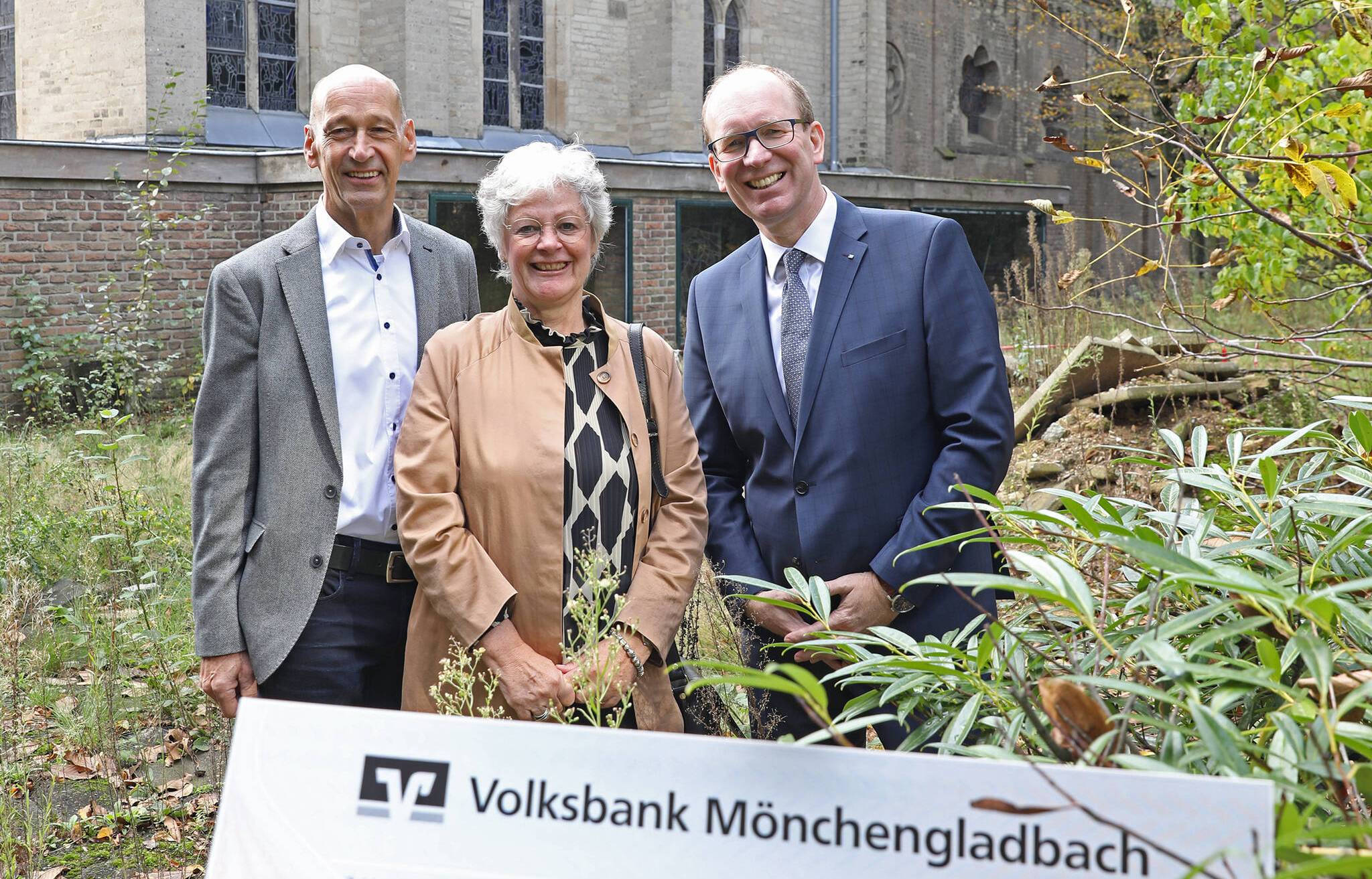 Johann Konder (l.) vom Radsportbezirk Mönchengladbach und Franz Dierk Meurers (r.), Vorstand der Volksbank Mönchengladbach, überreichten den Scheck über 2000 Euro an Anne Baus vom Münsterbauverein.