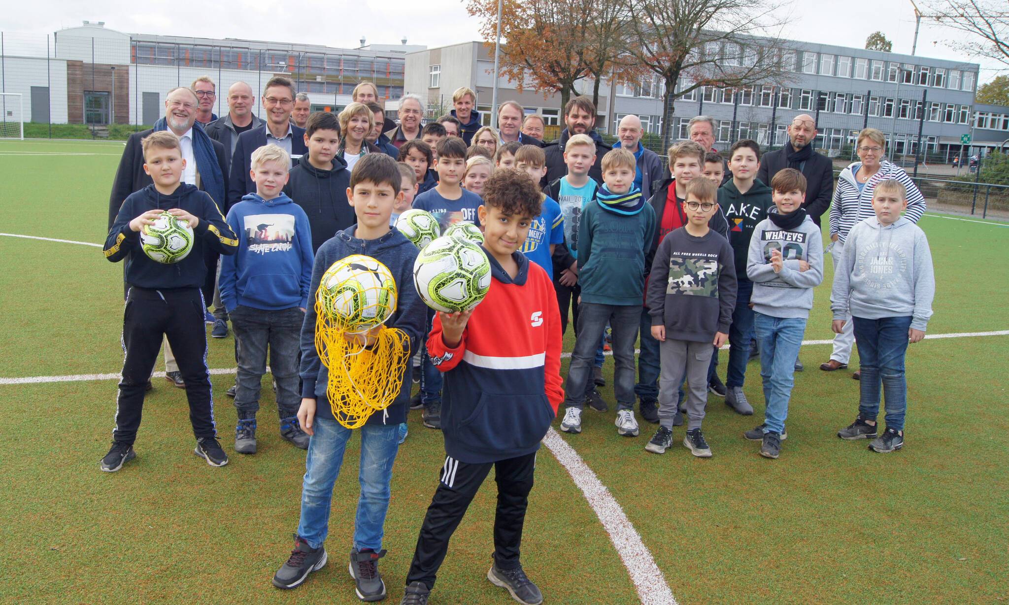 Schulen, Stadtverwaltung, Planer, Sportler und Schüler freuen sich über das Kunstrasenspielfeld.