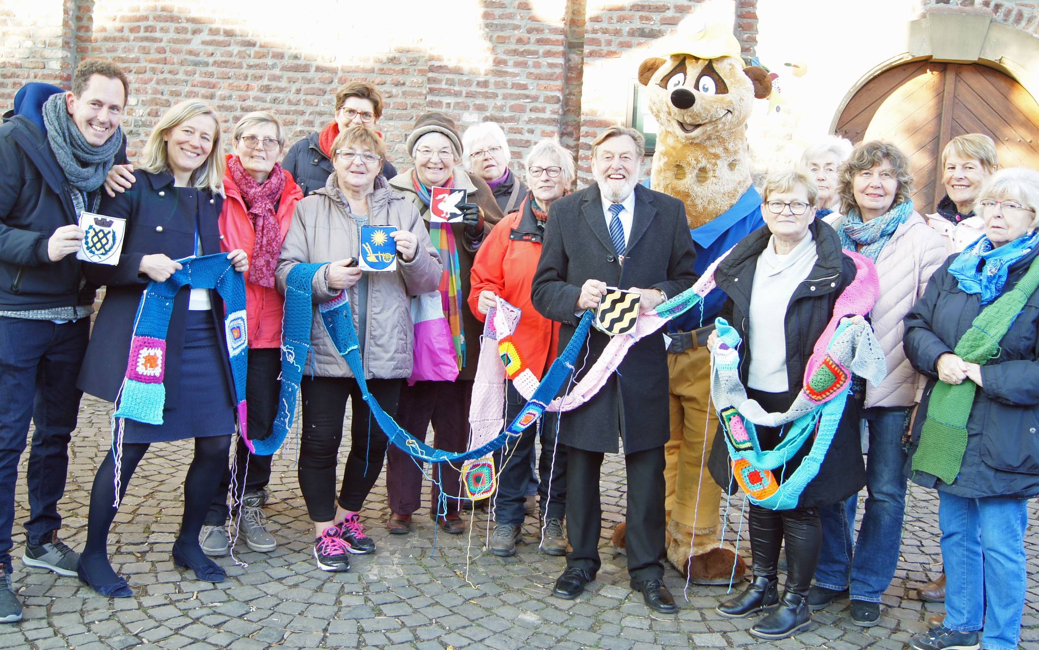 Stricken für die Landesgartenschau: Vertreter der Dorfmasche, des Städtepartnerschaftsvereins und der Partnerstädte mit Kerstin Radomski MdB (2.v.l.), dem stellvertretenden Bürgermeister Kurt Best (7.v.r.) und LaGa-Maskottchen Kalli.