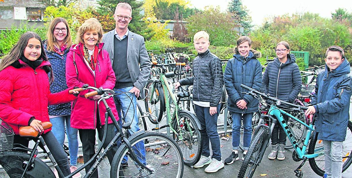  Sara (l.), Daniel, Nicole, William und Henry (v.r.n.l.), nutzen die neuen Fahrradständer regelmäßig. Denise Pottbäcker, Klima- und Nahmobilitätsmanagerin der Stadt Meerbusch, Bürgermeisterin Angelika Mielke-Westerlage und Schulleiter Klaus Heesen, freuen sich, dass der Fahrradparkplatz so gut angenommen wird.