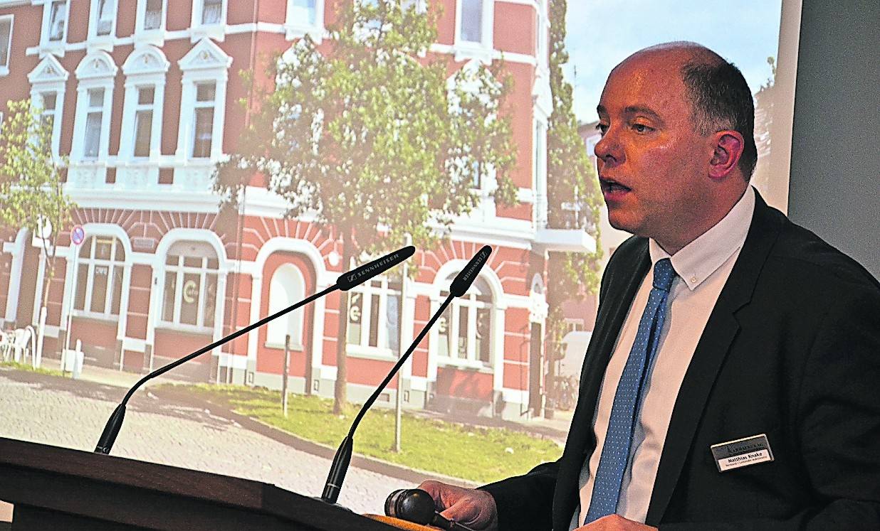 Auktionator Matthias Knake mit der Immobilie, die das höchste Gebot der Auktion erhielt: Bei 755.000 Euro fiel der Hammer für die Bachstraße 34 in Hochfeld.