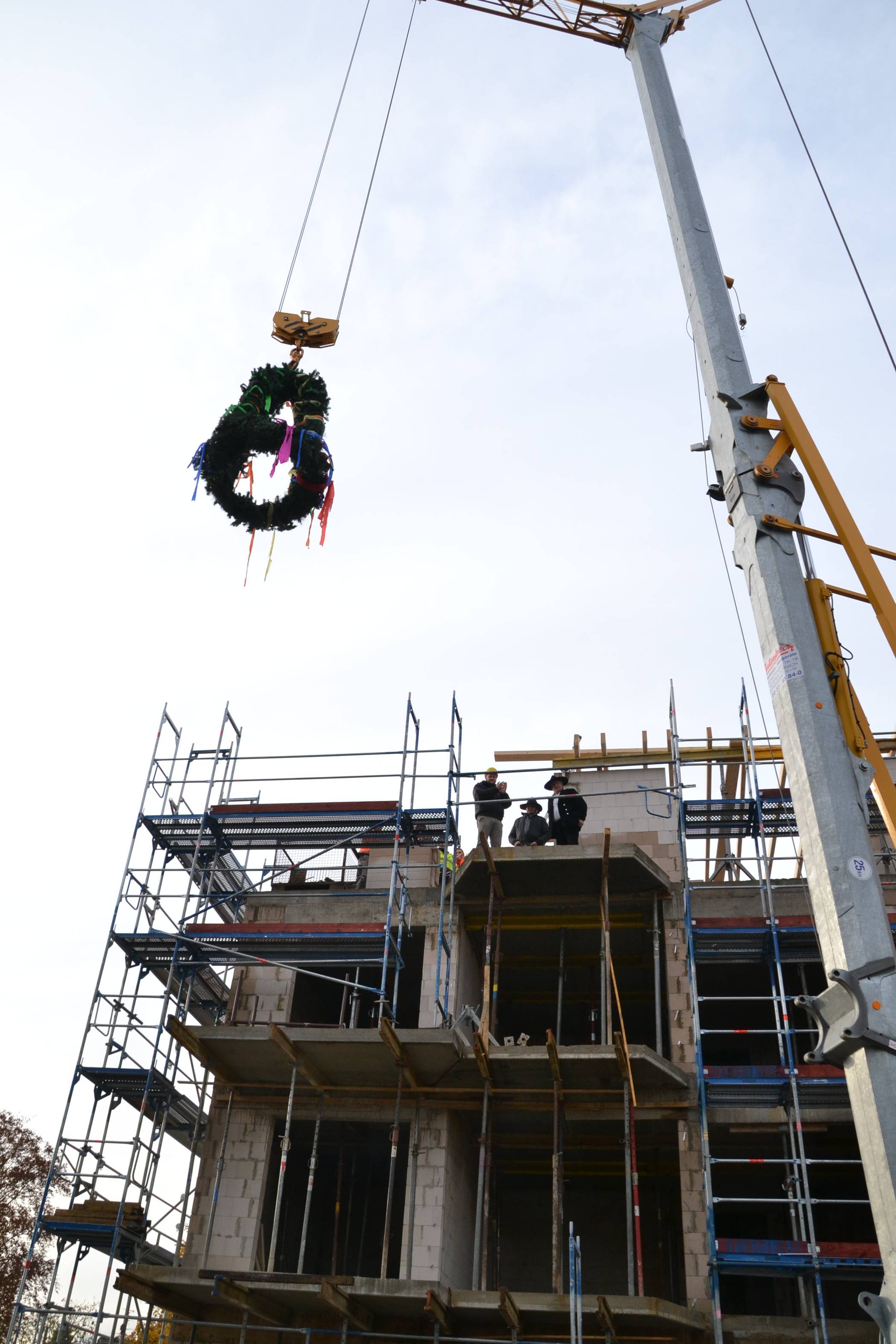  Oben angekommen, wurde die Richtkrone vom Zimmermann, der den Richtspruch zuvor ausgesprochen hatte, in Empfang genommen. 